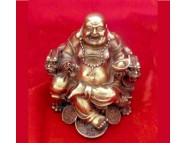 brass laughing buddha sitting in a dragon chair